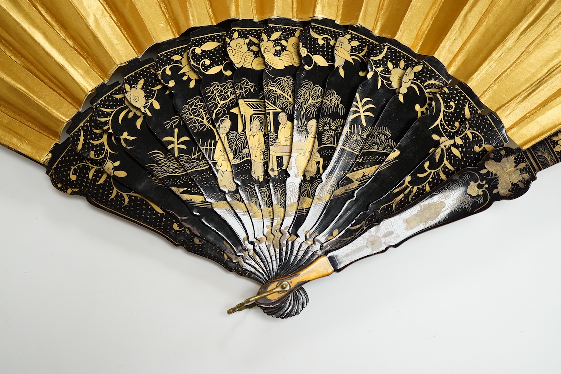 Four 19th century Chinese gilt-decorated black lacquer fans with figure painted leaves, two cased, largest 41cm